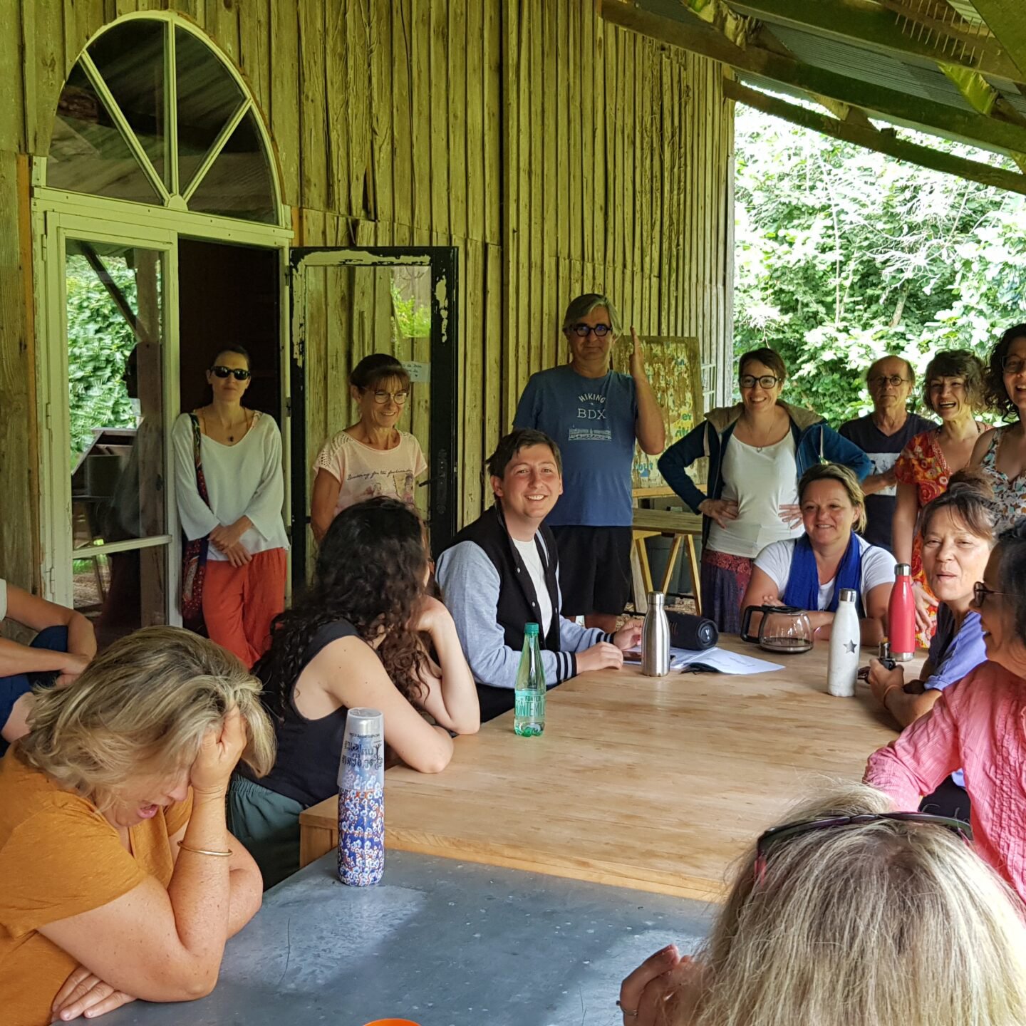 Photo du stage théâtre Jouer en liberté à Civrac Médoc : participants en immersion sous un préau en bois, en pleine discussion