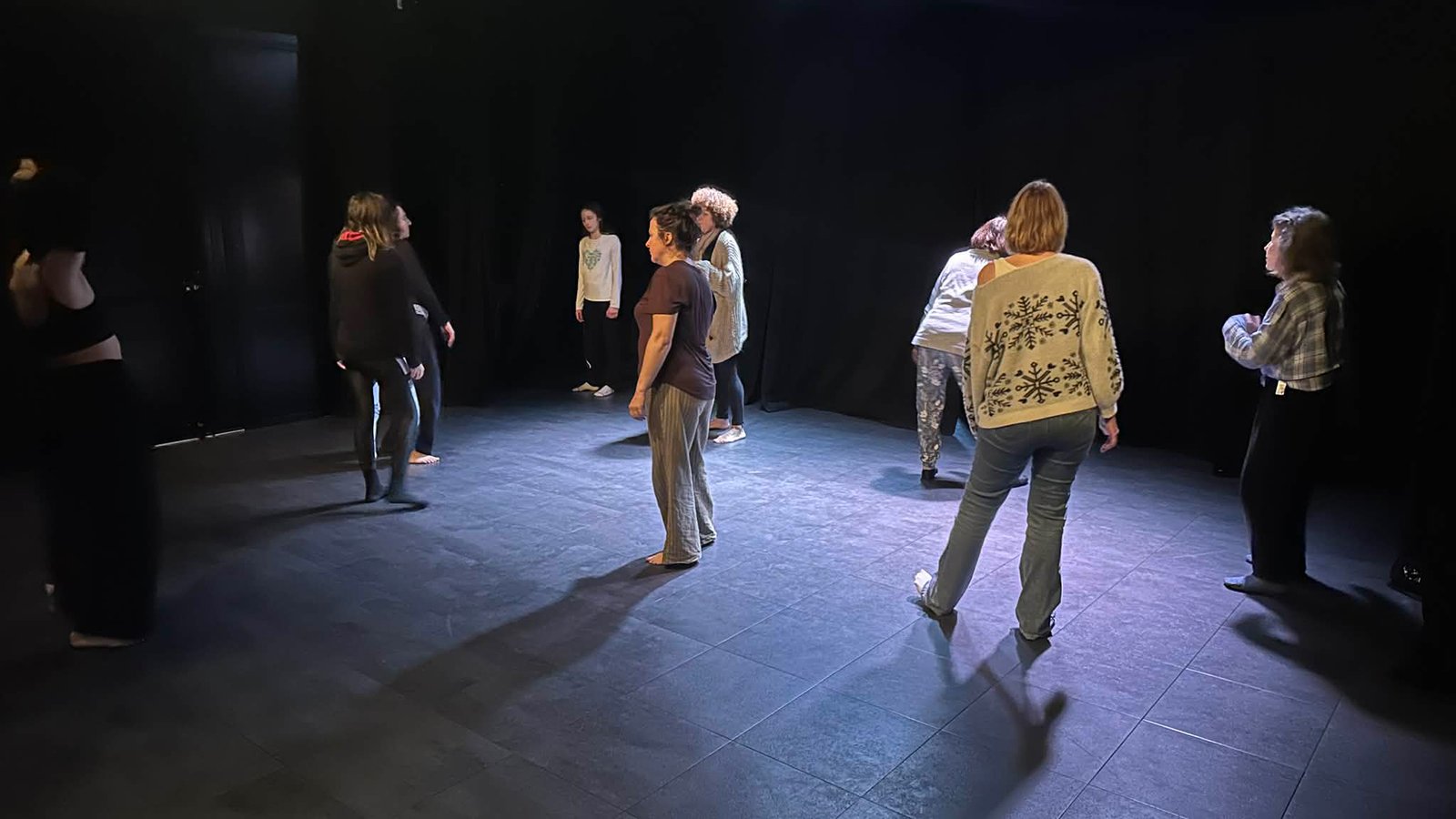 Participants d’un stage de perfectionnement théâtre à Bordeaux travaillant le mouvement et l’expression corporelle sur scène.