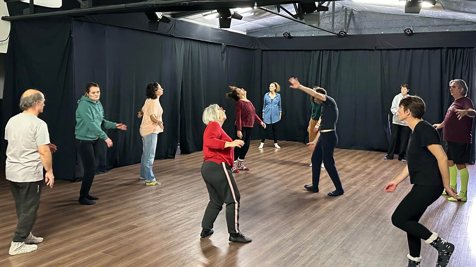 Groupe de participants réalisant un exercice collectif lors d’un stage de théâtre à Bordeaux dans un studio de répétition.
